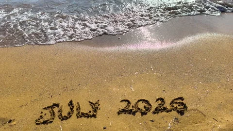 July 2026 text written on beach sand in slow motion Video stock 335758395