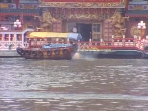 Jumbo floating restaurant and small boats sailing in a river Stock Footage 79878455