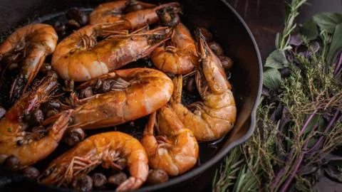 Jumbo shrimp grilled in skillet with rosemary and lemon Stock Photos