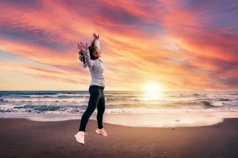 Jump on the beach at sunset Stock Photos