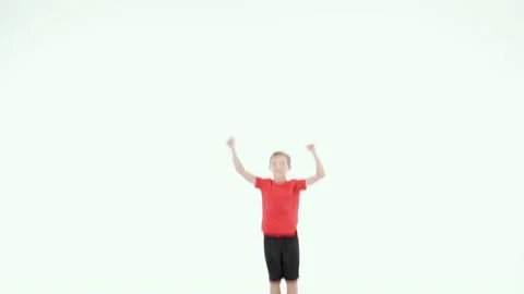 Jump for joy. Cute little elementary boy in red t shirt and black shorts smiling Stock Footage 149246523