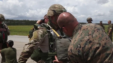 Jump master checking marine's parachute  Stock Footage 90120701