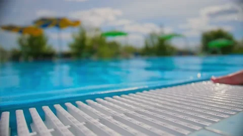 Jump into the pool, splash water into the camera. Blurred background in the Stock Footage 137028221