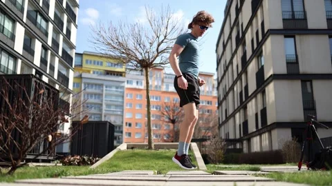 Jumping into action. A man stretches and warms up outdoors, gearing up for the w Stock Footage 305999973