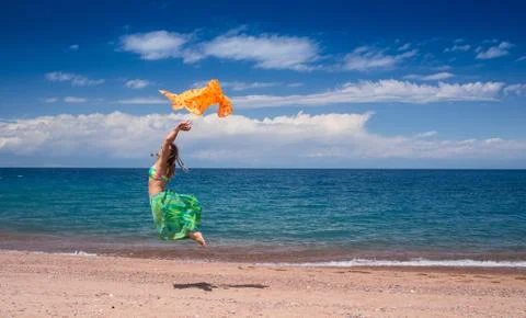 Jumping and dancing happy girl on the beach, fit sporty healthy sexy body in Stock Photos