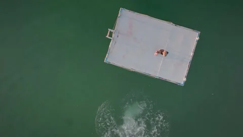 Jumping and diving off Swimming platform into the ocean Stock Footage 169726039