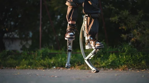 Jumping with Custom Spring Stilts in Outdoor Park Setting Vídeo Stock 293808256