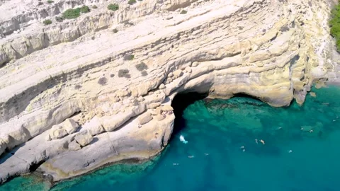 Jumping down a rock formation from a cliff into the ocean Stock Footage 261062101
