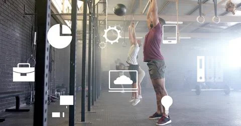 Jumping man maroon top gray shorts throwing medicine ball at box gym rigs icons, Stock Photos