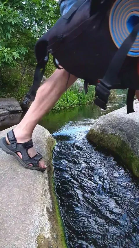 Jumping over a mountain stream. Stock Footage 245706521