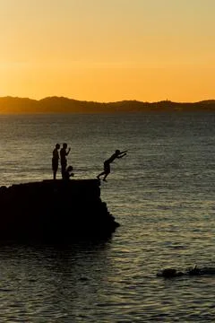 Jumping off the pier at dusk. Stock Photos