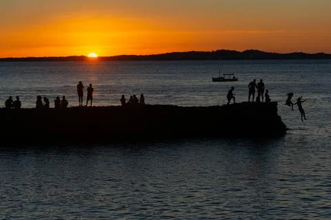 Jumping off the pier at dusk. Stock Photos