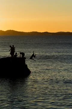 Jumping off the pier at dusk. Stock Photos