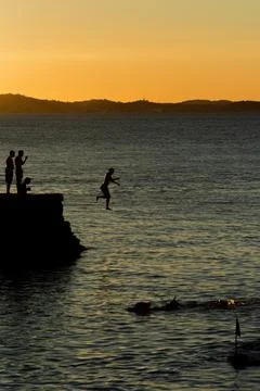 Jumping off the pier at dusk. Stock Photos