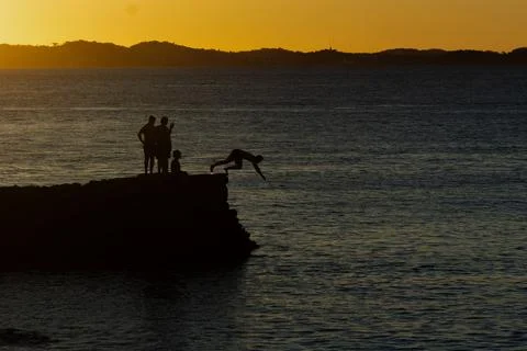 Jumping off the pier at dusk. Stock Photos