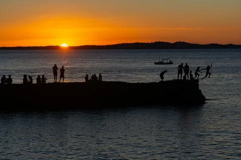 Jumping off the pier at dusk. Stock Photos