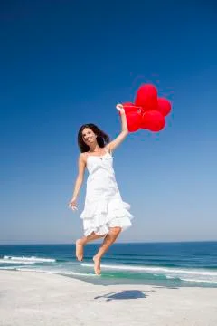 Jumping with red ballons Stock Photos