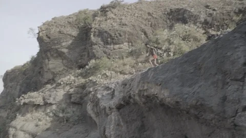 Jumping off rocks into water Stock Footage 90590861