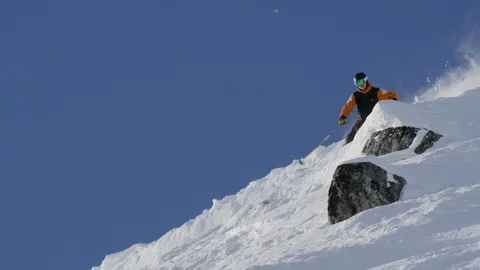 Jumping skier skiing over the snow covered mountain slope Stock Footage 116631480