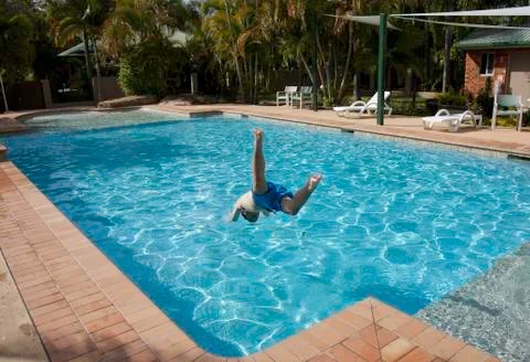 Jumping into swimming pool Stock Photos