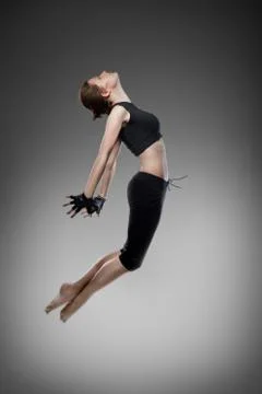 Jumping young dancer on black Photos
