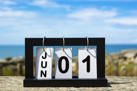 Jun 01 calendar date text on wooden frame with blurred background of ocean Stock Photos