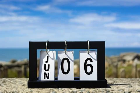 Jun 06 calendar date text on wooden frame with blurred background of ocean. Stock Photos