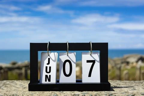 Jun 07 calendar date text on wooden frame with blurred background of ocean. Stock Photos
