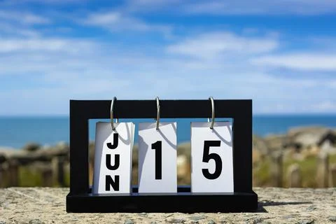 Jun 15 calendar date text on wooden frame with blurred background of ocean. Stock Photos