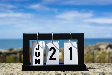 Jun 21 calendar date text on wooden frame with blurred background of ocean. Stock Photos