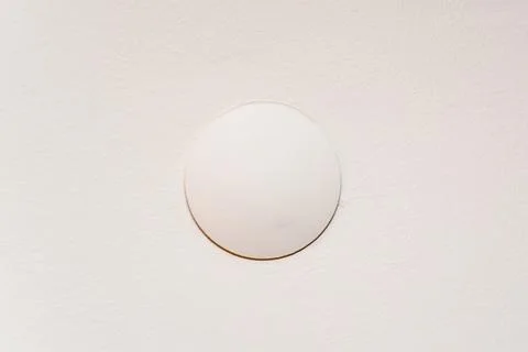 The junction box cover that covers the cables on the cream colored wall Stock Photos