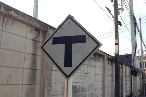 Junction sign on square shape and dirty wall. Stock Photos