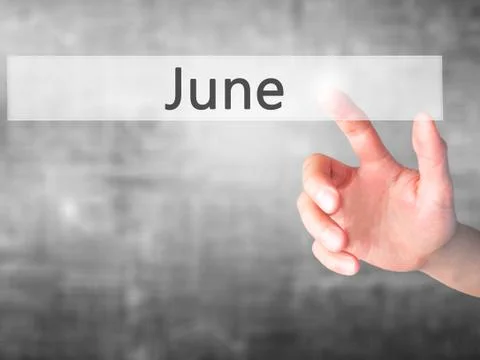 June - Hand pressing a button on blurred background concept on visual screen. Stock-Fotos