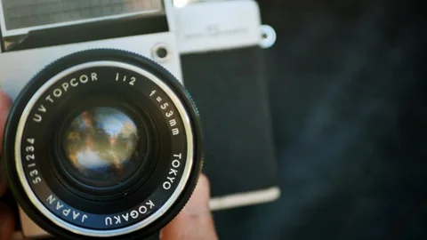 A jung man preparing focus and apertura on a retro 35 mm camera. 4k Stock-Footage 119724052