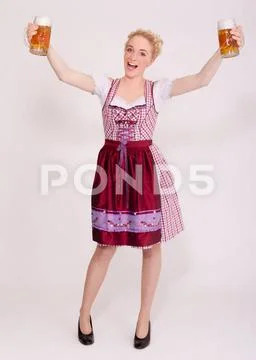 Junge Frau im Dirndl mit zwei vollen Bierkrüge Bie Junge bayerische ...