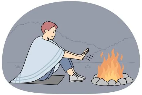 Junger Mann wärmt Hände am Feuer Young man sit on ground in nature warm ha. Stock Photos
