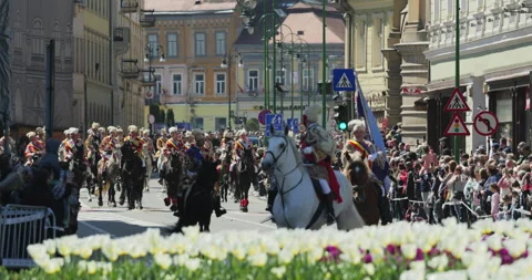 Junii Brasovului parade featuring men in traditional folk costumes on horses Video stock 333937205