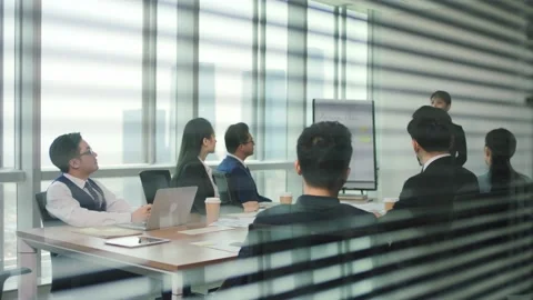 Junior asian employee speaking during staff meeting in conference room Stock Footage