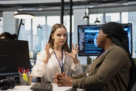 Junior dev and female programmer gossiping about coworkers, having fun Foto stock