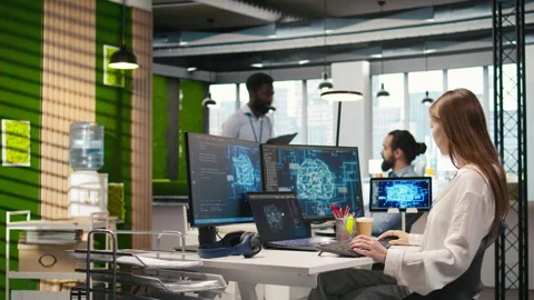 Junior dev in office relies on AI tech to run tasks across multiple devices Stock Footage 313168039