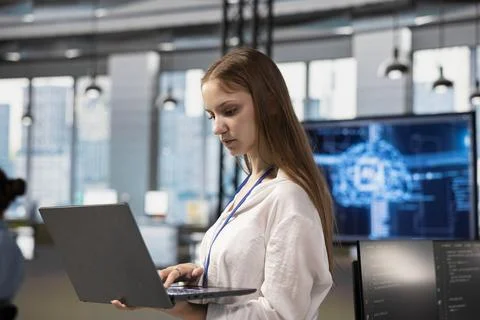 Junior dev in office using AI automation to reduce repetitive coding tasks Foto stock