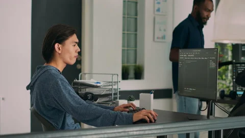 Junior developer writing database code to create new user interface on computer Stock Footage 222022733