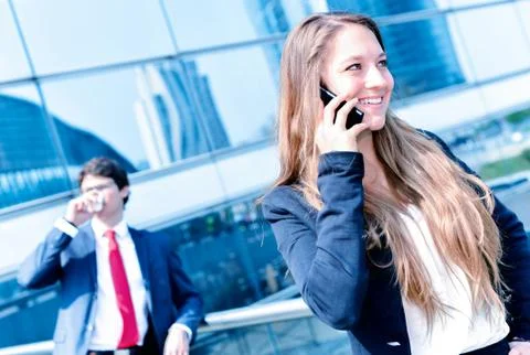 Junior executive dynamic phoning outside of her office Stock Photos