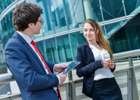Junior executives having a coffee break in front of their company Stock Photos