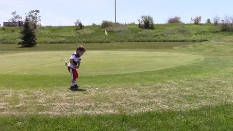 Junior golfer holes chip shot and bows Stock Footage