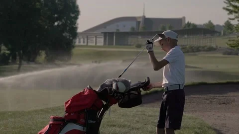 Junior golfer playing golf on summer with hitting shot on green grass Stock Footage 95128042