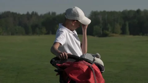 Junior golfer playing golf on summer with hitting shot on green grass Stock Footage 95129566