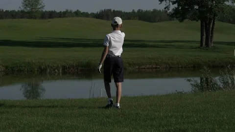 Junior golfer playing golf on summer with hitting shot on green grass Stock Footage 95132095