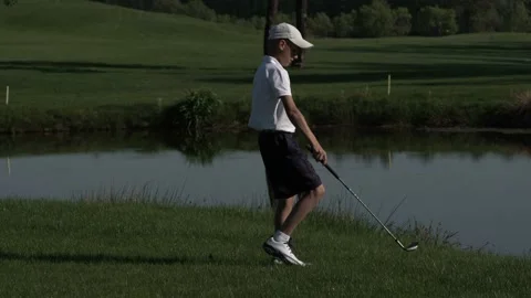 Junior golfer playing golf on summer with hitting shot on green grass Stock Footage 95132286