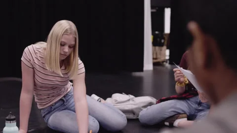 Junior high drama students practicing script on theater stage Stock Footage 220945684